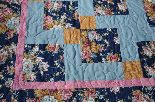 A closer look at the fabrics and disappearing nine patch pattern used in the quilt.