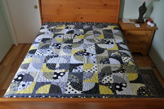 A quilt in yellows, grays, black and white using the 'crazy curves' template & design.